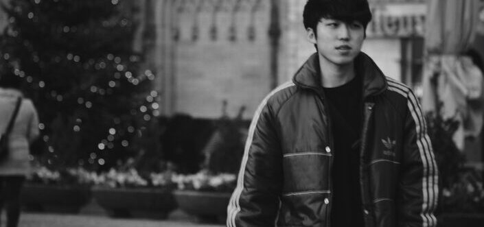 Young man wearing winter hoody walking down the street