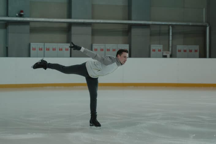 Man in gray jacket and black pants doing stunts