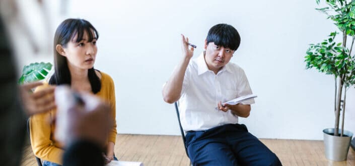 Man raising hand while in group discussion