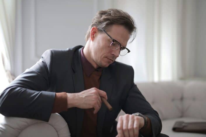 man in black suit sitting on white couch