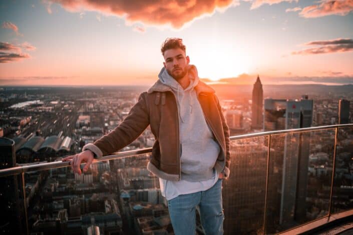 Man on top of a building rooftop while sunset