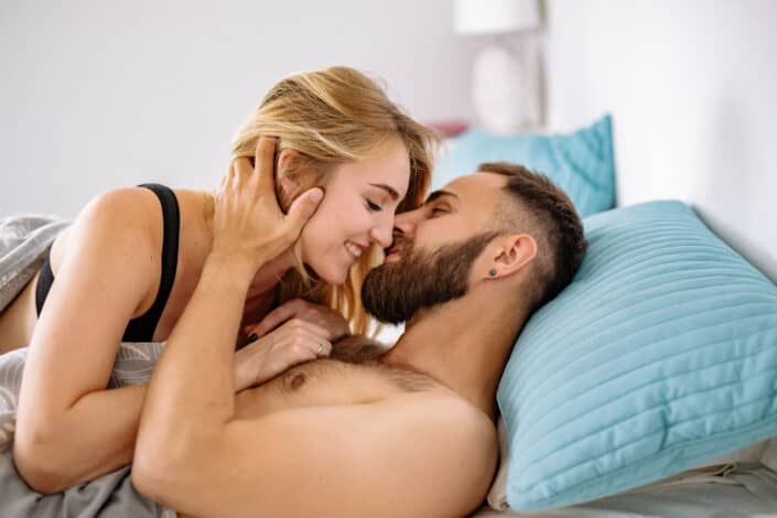 Couple being touchy and romantic in bed
