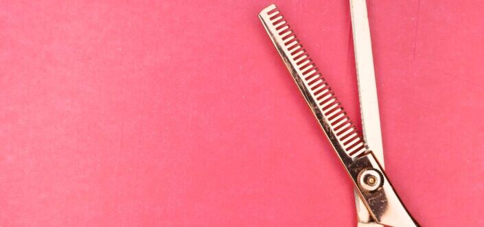 silver scissors on red textile