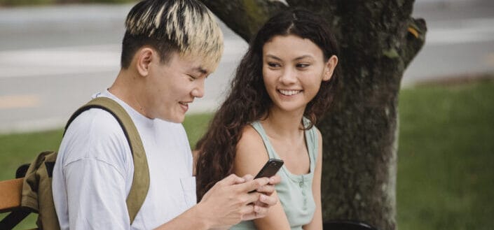 Smiling couple browsing smartphone