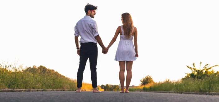 Couple in white clothing holding hands