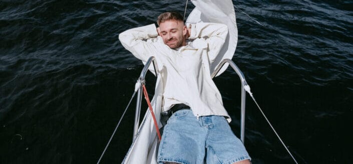 man sitting on white boat