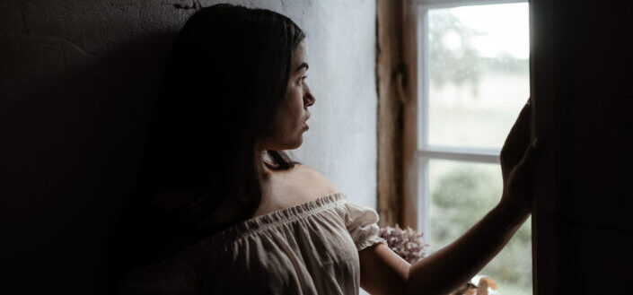 Woman standing beside window