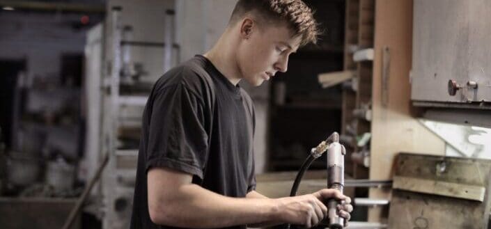 Young mechanic attentively working in workshop