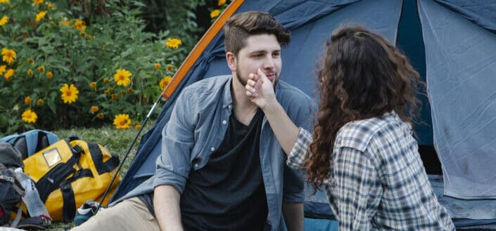 woman touching boyfriends face during romantic picnic