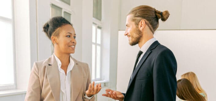 A businessman and businesswoman talking together