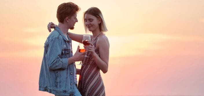 Romantic Couple Holding Wine Glasses During Sunset
