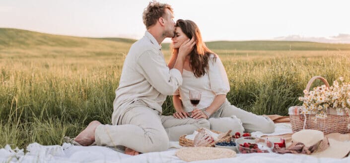 man kissing a woman on the forehead