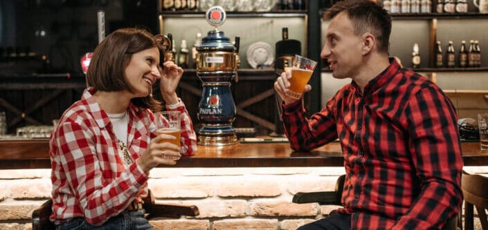 Man and woman sitting on chairs at the bar