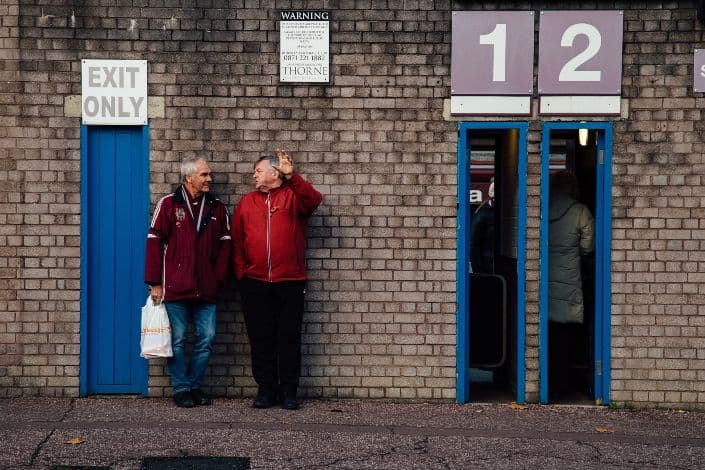 two elderly men talking outside