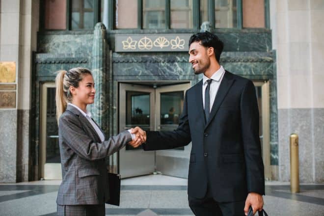 What type if woman us an alpha male attracted to - Man and woman in business attire shaking hands