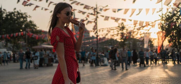 Girl in red dress eating bread on taksim square
