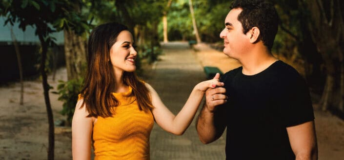 A couple holding hands looking at each other