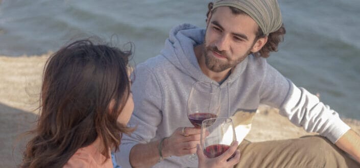 Couple Drinking Red Wine at the Beach