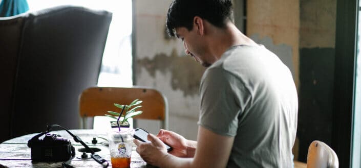 Focused Man Surfing Smartphone in Cafe