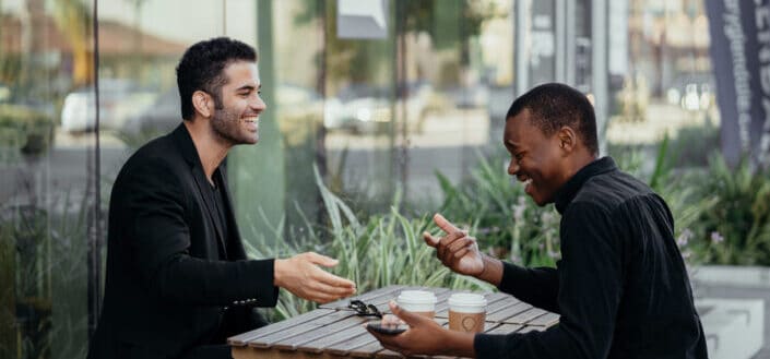 Happy male colleagues talking to each other