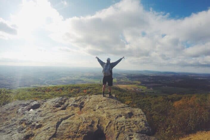 Man Reaching Cliffside