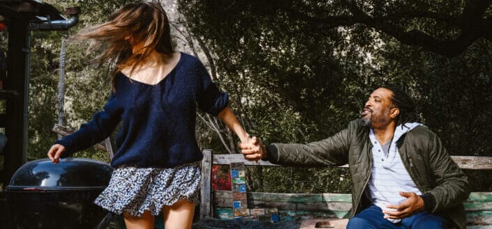 Man sitting grabbing a woman's hand