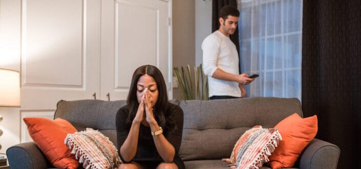 woman looking pensive with man behind her