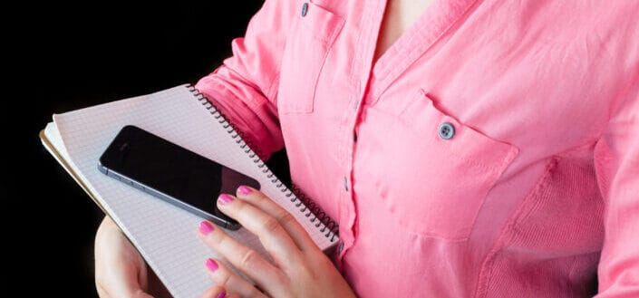 Person Holding Phone and Notebook