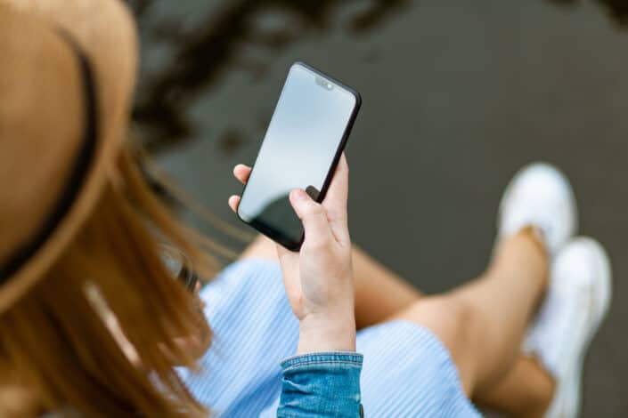 Person Holding Smartphone While Sitting