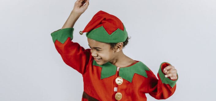 a happy boy in bright costume of elf dancing