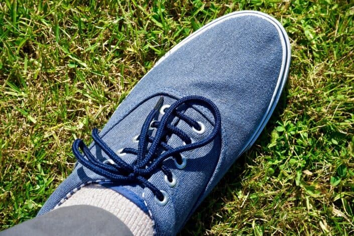 Blue Sneakers Stepping on Grass