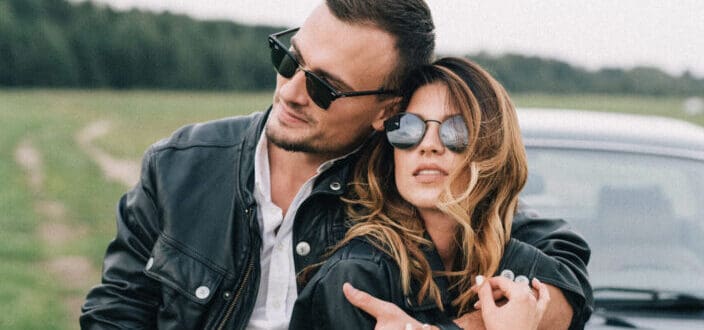 Stylish couple in sunglasses embracing