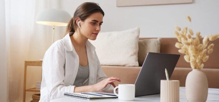 Woman With Earbuds Using Laptop