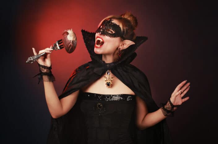 Woman in black dress wearing black mask