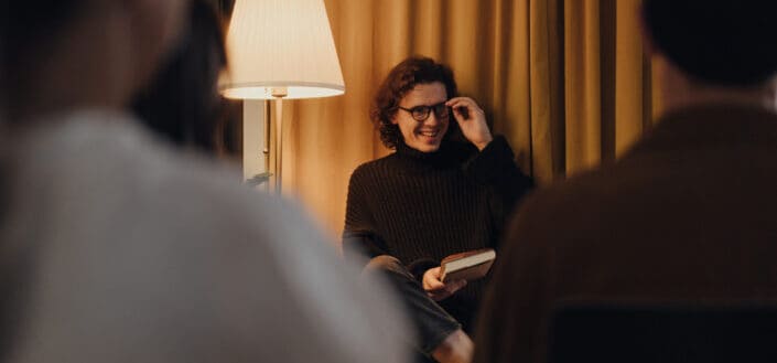 man holding a book smiling