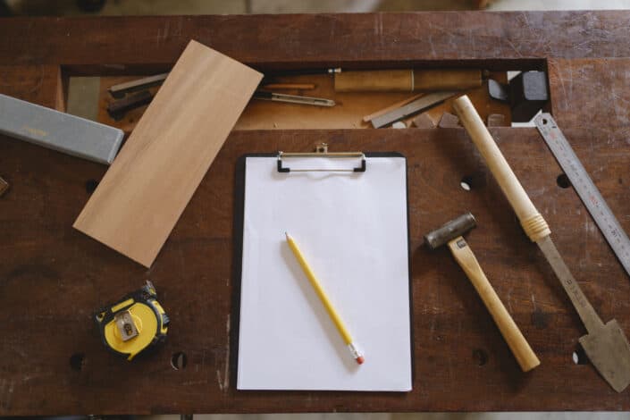 Yellow Pencil on White Paper and Carpentry Tools