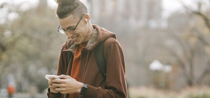 guy smiling while listening to music on smartphone