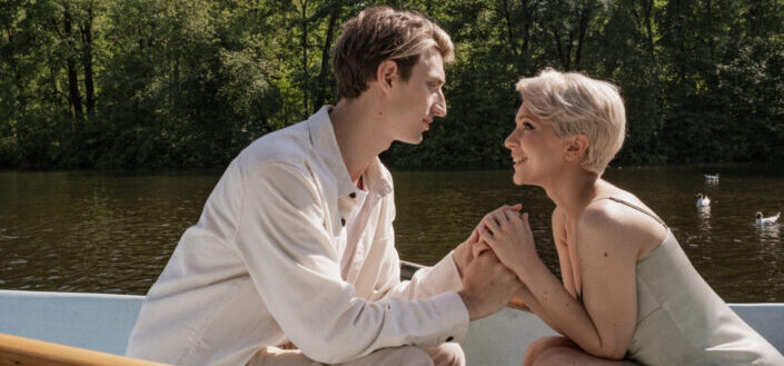 Couple Sitting on Boat While Holding Hands