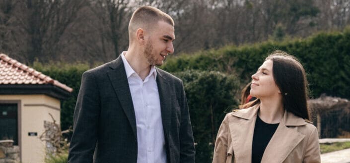 A romantic couple holding hands while walking