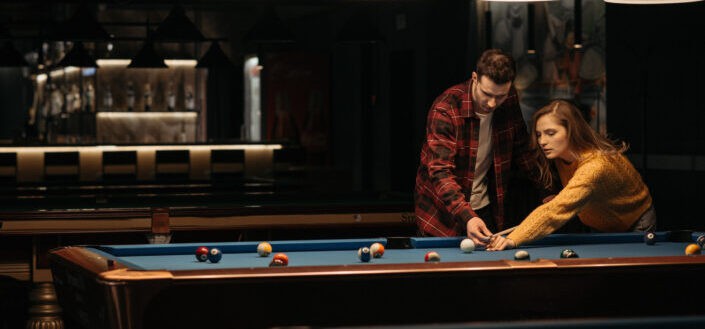 A woman learning how to play billiards