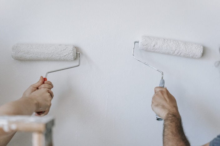 Anonymous people painting the wall