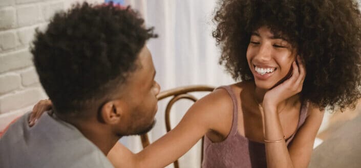 Couple sitting at table in apartment and talking