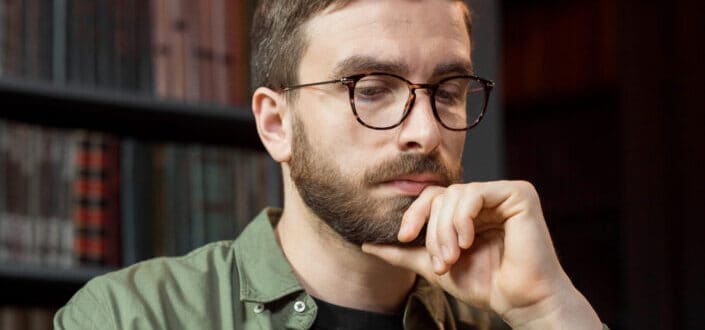 a man with eyeglasses deep in thought