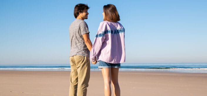 Couple holding hands on shore