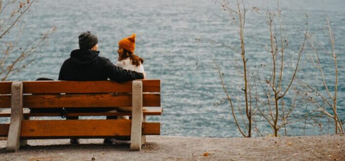 Couple Sitting on a Bench by the Lake