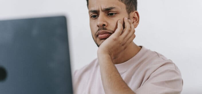 Pensive Man Looking at His Laptop
