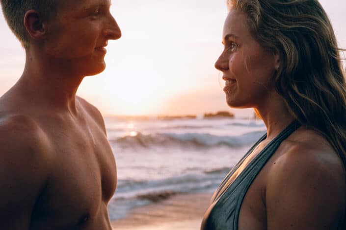 man and woman at beach during sunset