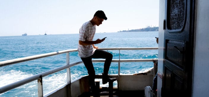 Man on Ship Deck Using His Phone
