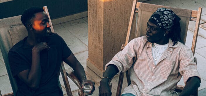 Men sitting on chair having a conversation