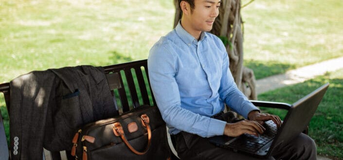 Person Using a Laptop on a Park Bench